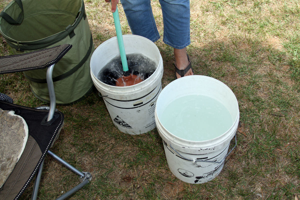 washing clothes with a plunger and bucket as a natural washing machine
