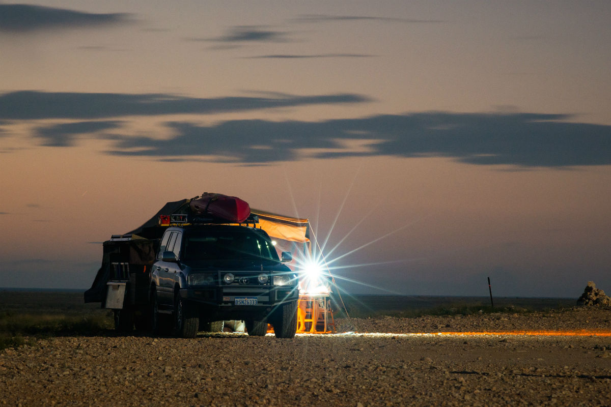 4WD parked in the desert during sunset with a flood light on