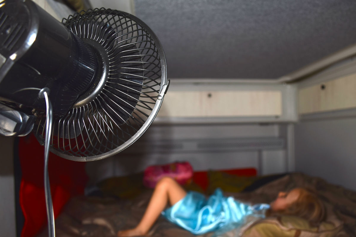 girl lying on caravan bed with the fan on