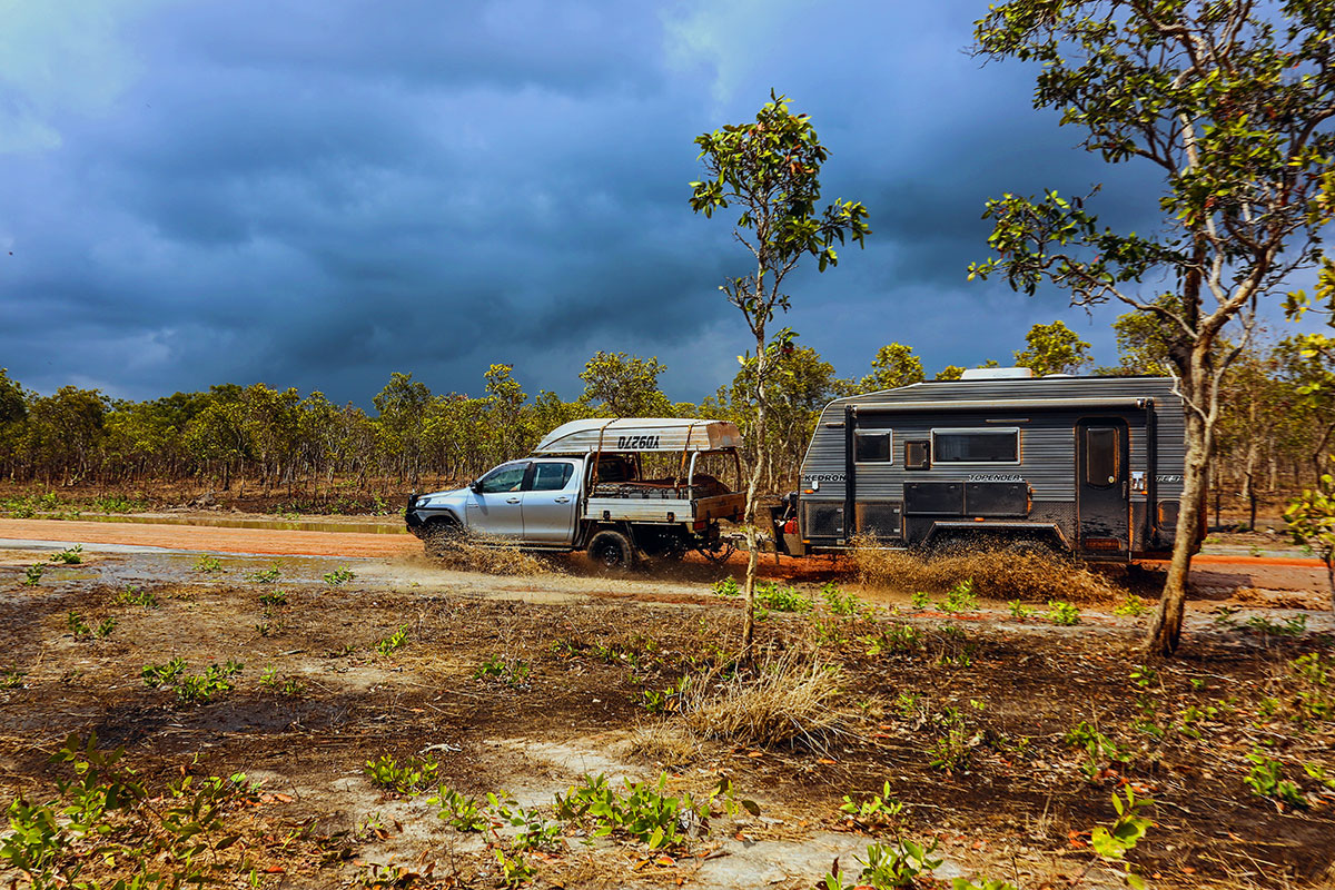 4WD towing a caravan on a country dirt road on a cloudly day