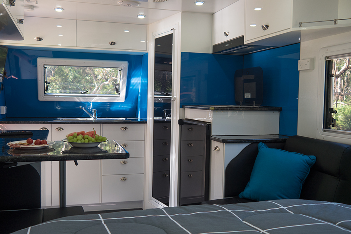 Inside a caravan, bed and kitchen