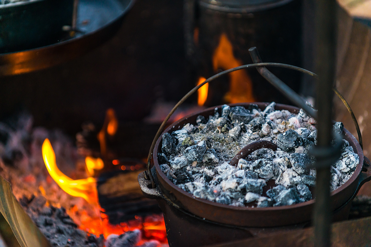 Camper oven on hot coals in a fire place