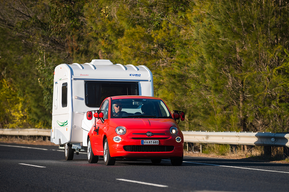 Little red Fiat towing a caravan