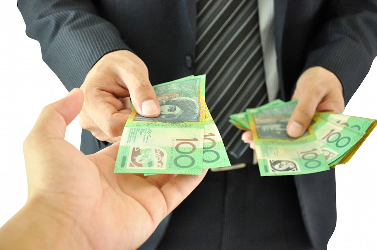Businessman hand giving money - Australian dollars