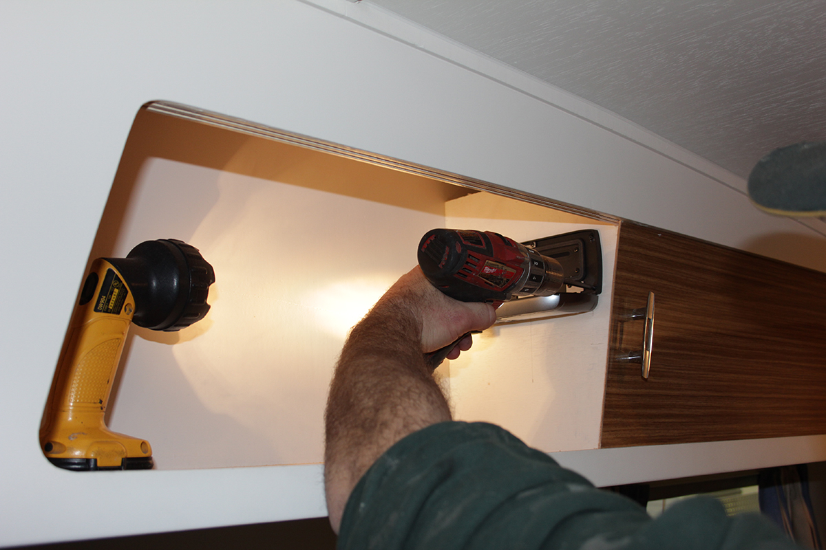 Screwing-the-stereo-on-the-caravan-wall