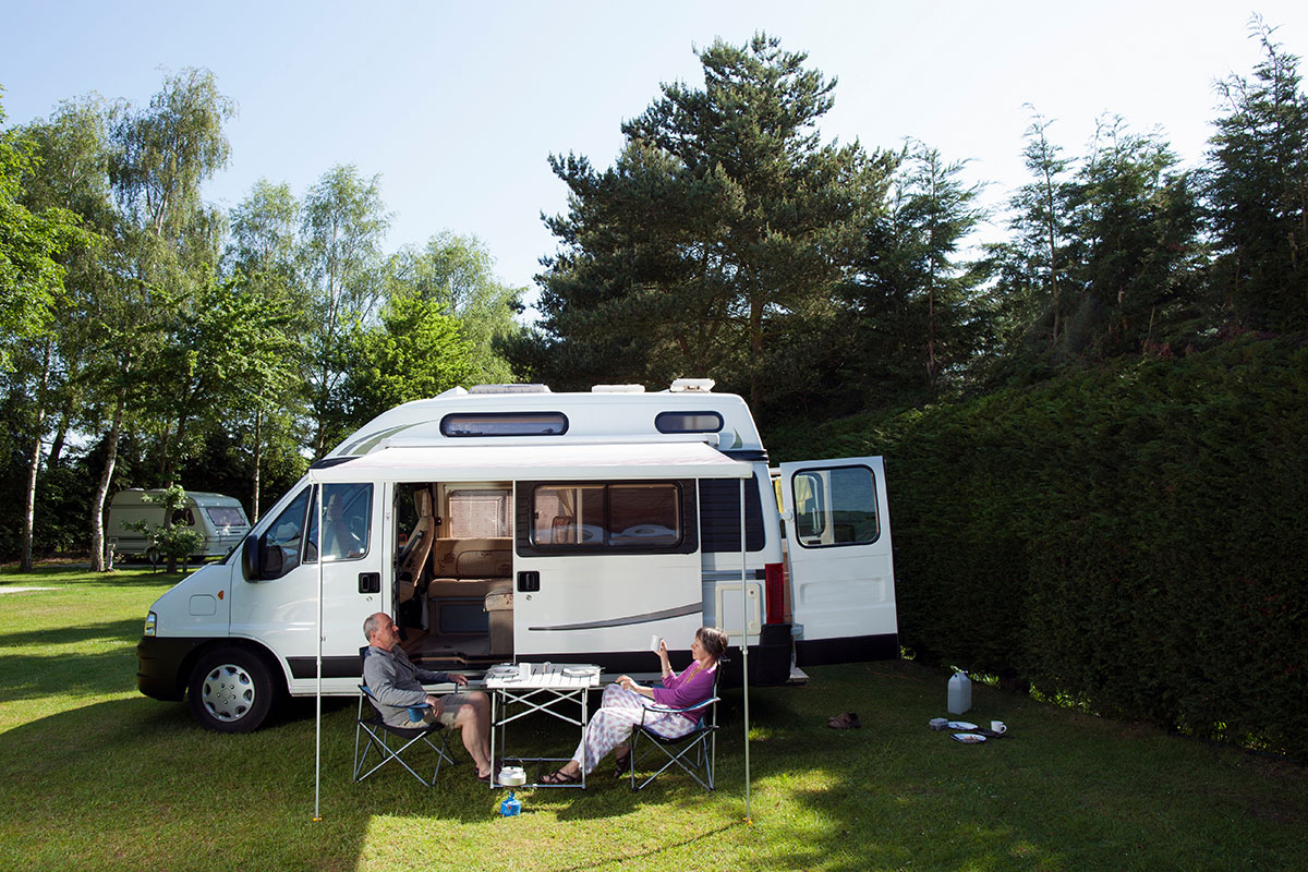 Couple-sitting-next-to-a-motorhome